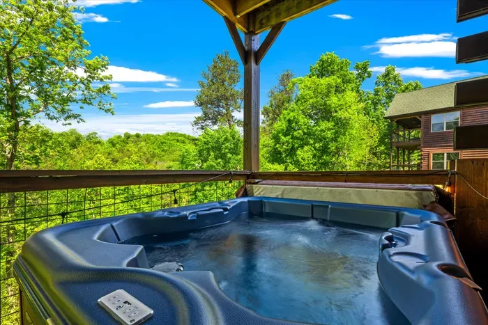Private covered deck hot tub with serene mountain and forest views