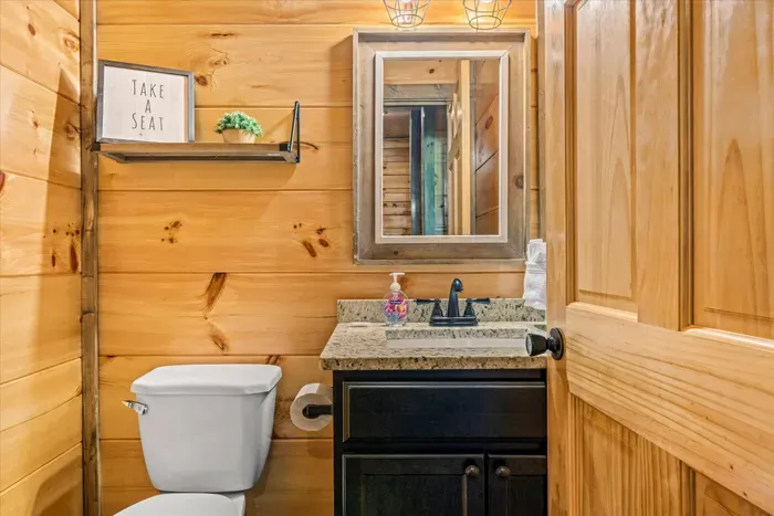 Cozy cabin bath with granite vanity, black fixtures & warm wood.