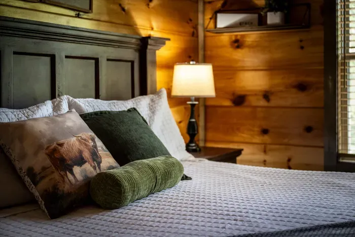 Cozy cabin bedroom with plush bedding and warm ambient lighting