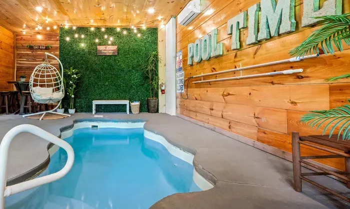 Private indoor plunge pool with tiki bar, swing chair and string lights