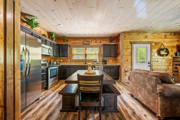 Rustic cabin kitchen with stainless appliances and farmhouse table