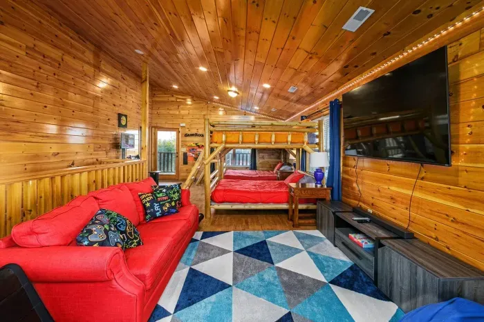 Third level movie viewing area with 75” smart TV, sound bar, sofa, bean bags and LED lighting 