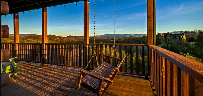 Covered deck with porch swing and sweeping mountain sunset views.