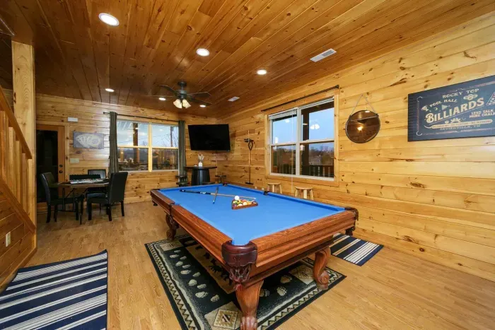 Second level lounge area with billiard table, large screen smart TV, poker table, and oak barrel lounge seating 