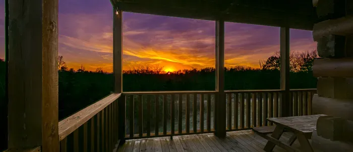 Covered cabin deck with sunset views—perfect for outdoor dining.