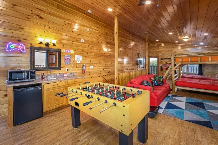 Third floor gaming area with popcorn bar, 75” TV with soundbar, and games 