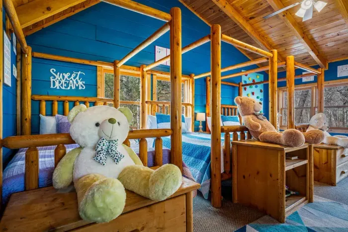 Charming log kids’ room with twin beds, forest views, and fun decor