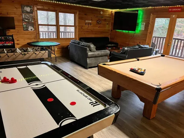 Game room with billiards, air hockey, foosball, poker table, arcade, movie viewing area and lounge seating 