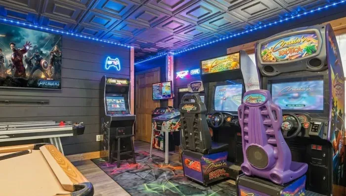 Arcade-style game room with racing pods, TV, pool & air hockey