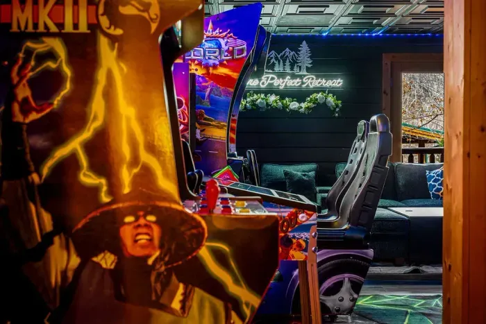Retro arcade lounge: racing seats, neon glow, and plush sectional.