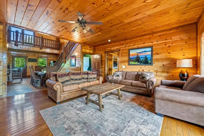 Warm, spacious log cabin living room with loft and cozy seating