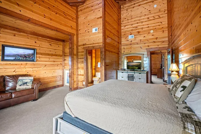 Spacious rustic bedroom with vaulted wood ceilings and cozy cabin charm