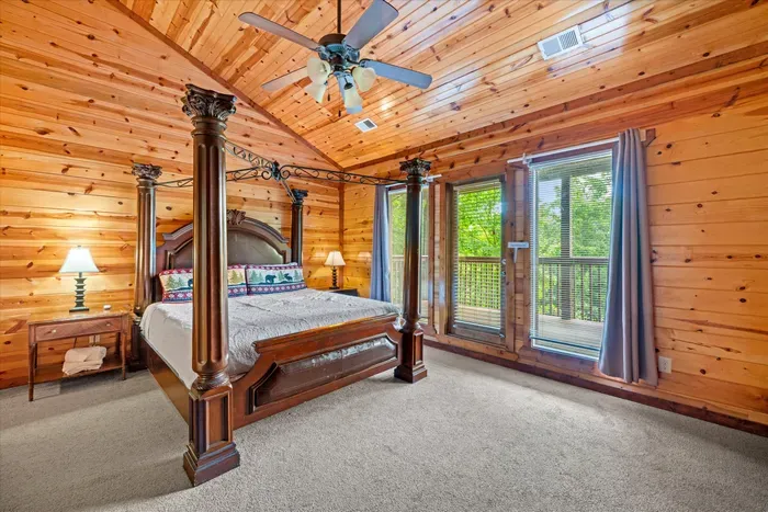 Cozy wood-paneled bedroom with four-poster bed and private balcony views