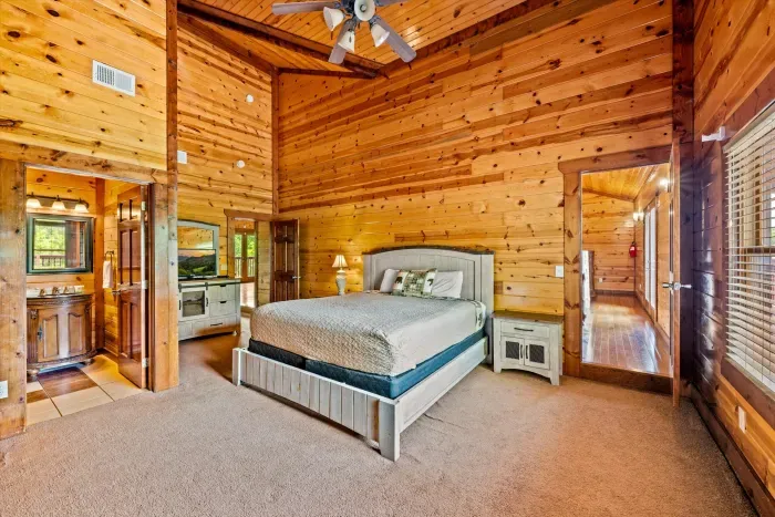 Spacious rustic cabin bedroom with vaulted ceilings and ensuite access