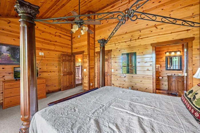 Rustic king bedroom with soaring wood ceilings and elegant four-poster bed