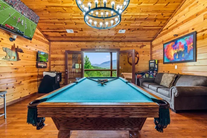 Rustic game room with pool table, TVs, and stunning mountain views