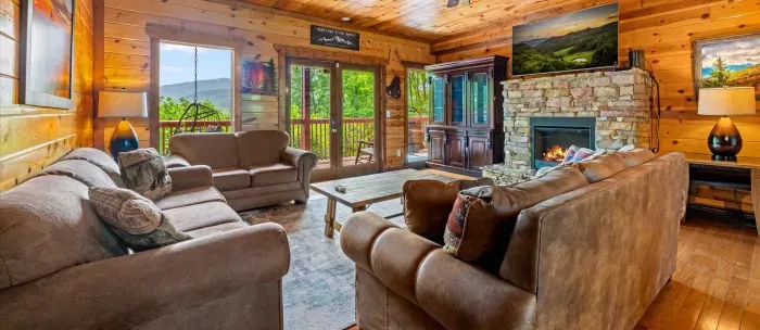 Cozy mountain-view living room with stone fireplace and spacious seating