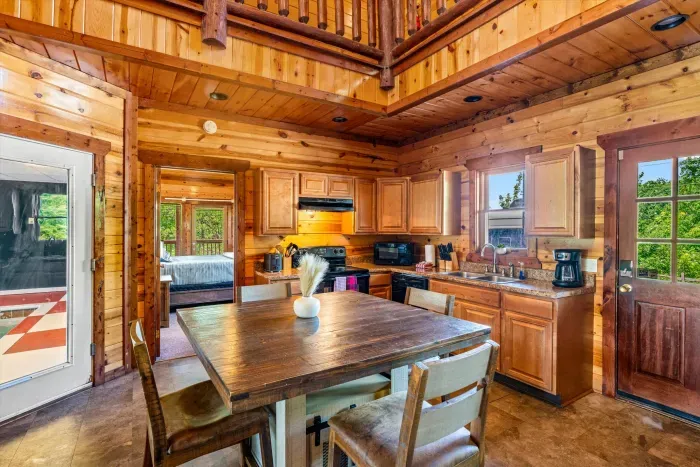 Cozy wood-clad cabin kitchen with dining space and open loft charm