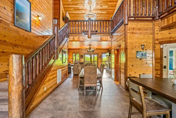 Warm rustic great room with loft, open staircase, and spacious dining area