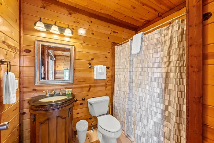 Cozy cabin-style bathroom with warm wood finishes and full tub-shower