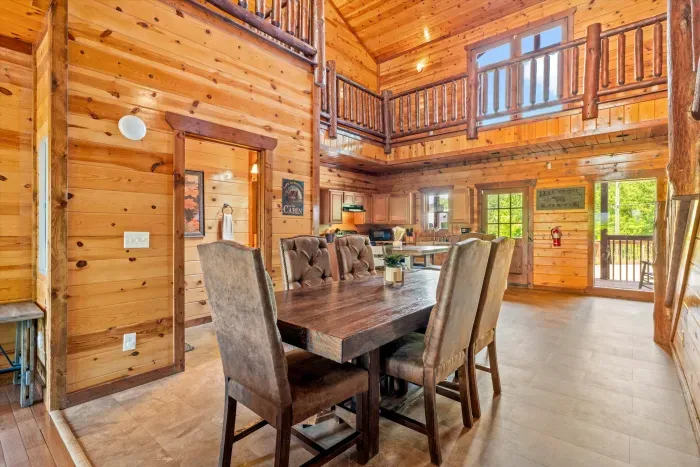 Rustic open-concept cabin with loft, vaulted ceilings, and spacious dining
