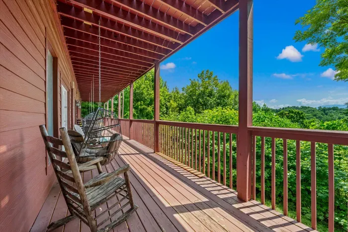 Covered porch with rocking chairs and მშვიდ treetop views