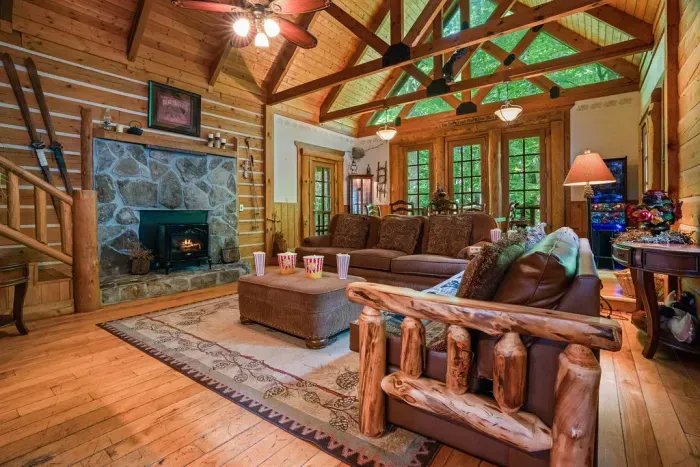 Cozy cabin great room with stone fireplace and stunning forest views