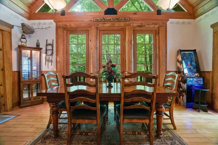 Rustic woodland dining room with vaulted ceilings and scenic forest views