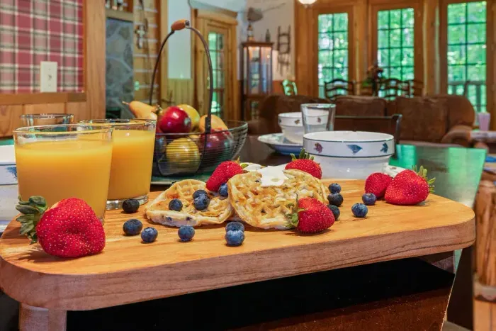 Cozy rustic kitchen with a fresh breakfast spread and forest views