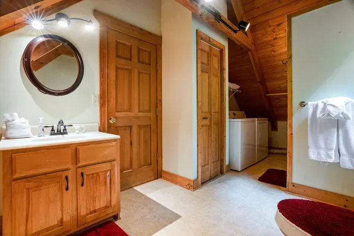 Rustic loft bathroom with wood accents and in-unit washer/dryer