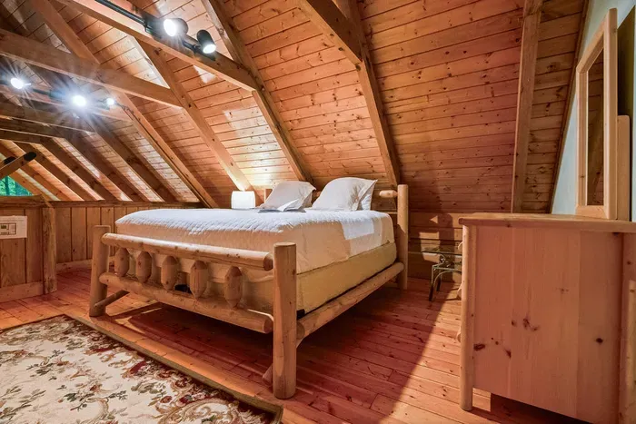 Cozy loft bedroom with rustic log bed and warm wood cabin charm