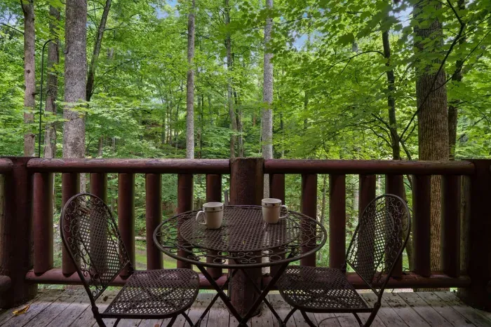 Private forest-view deck with cozy bistro seating for morning coffee