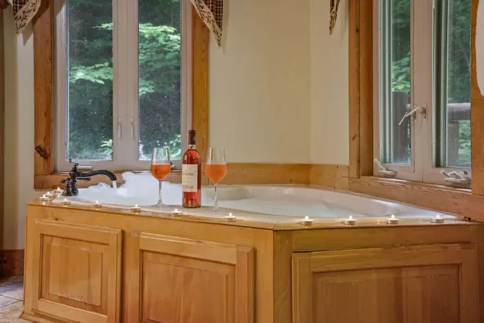 Spa-like soaking tub with forest views and a cozy, romantic ambiance