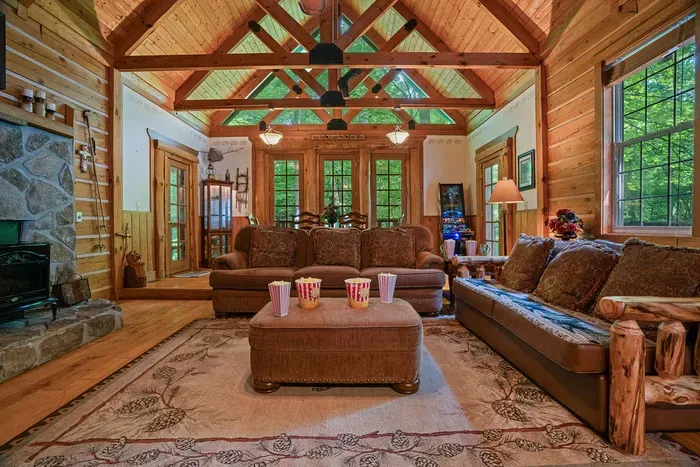Vaulted timber great room with forest views and cozy lodge seating