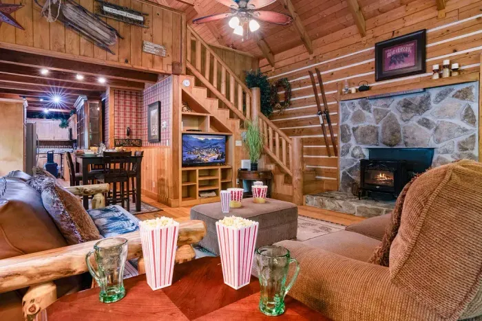 Cozy log cabin lounge with stone fireplace and warm rustic charm