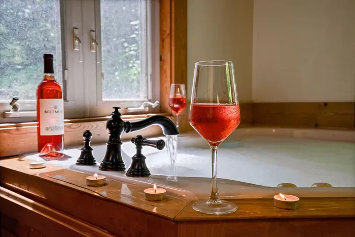 Romantic jetted soaking tub with candles and wine for a spa-like retreat