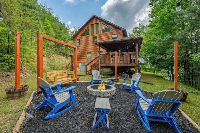 New fire pit with adirondeck chairs, cafe lights and hanging porch style swing