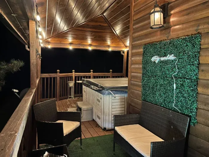 Seating area with cafe lights near covered hot tub 