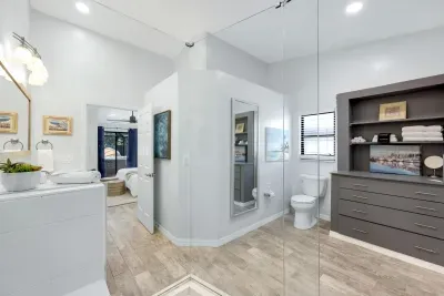 Modern master en suite with a full-length mirror, ample storage, and a spa-like atmosphere—perfect for relaxing in style and comfort.