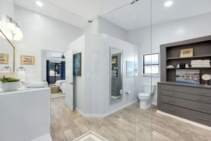Modern master en suite with a full-length mirror, ample storage, and a spa-like atmosphere—perfect for relaxing in style and comfort.