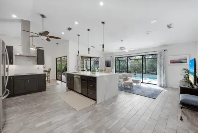 Fully updated kitchen and family room with fully opening sliding doors and a stunning pool view- ideal for vacation relaxation.uu