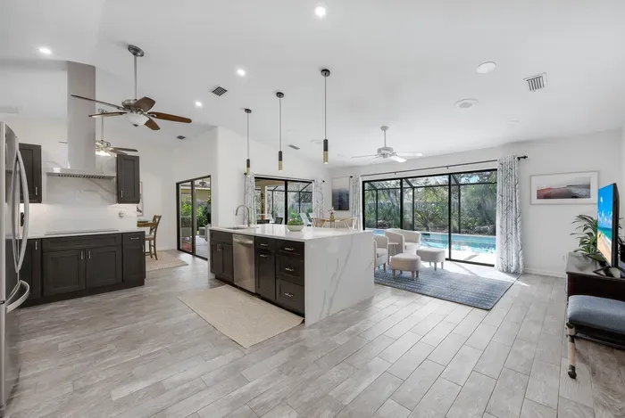 Fully updated kitchen and family room with fully opening sliding doors and a stunning pool view- ideal for vacation relaxation.uu