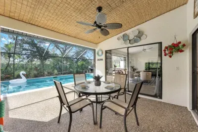Charming lanai with cozy dining table and cooling ceiling fans-perfect for al fresco dining during your stay.