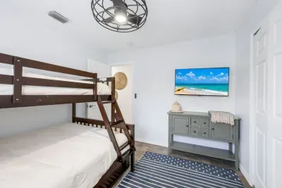 Comfy bedroom with a TV and bunk beds featuring a full bed on the bottom, twin on top, and a twin trundle—perfect for kids or groups.