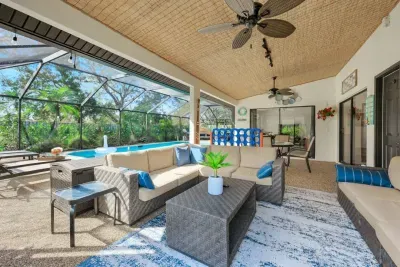Tropical lanai with ample seating, outdoor TV, and fun vibes featuring a giant Connect 4 game.