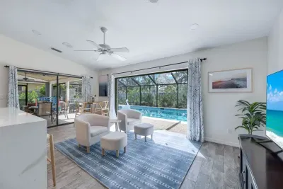 Inviting family room with a breakfast nook and pocket sliding doors to pool area, comfy chairs, and a TV-great for unwinding.
