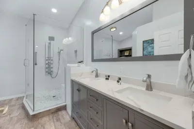 Luxurious master en suite with a spacious double-sink vanity and a large walk-in shower featuring multiple jets for a spa-like experience.