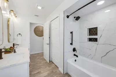 Sleek and modern guest bathroom featuring a stylish shower/tub combo—perfect for a relaxing soak or quick rinse after a day by the pool or at the beach.