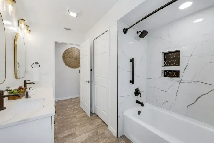 Sleek and modern guest bathroom featuring a stylish shower/tub combo—perfect for a relaxing soak or quick rinse after a day by the pool or at the beach.