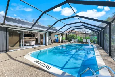 Poolside fun with outdoor TV in lanai, giant Connect 4 and sliding doors leading to the house.